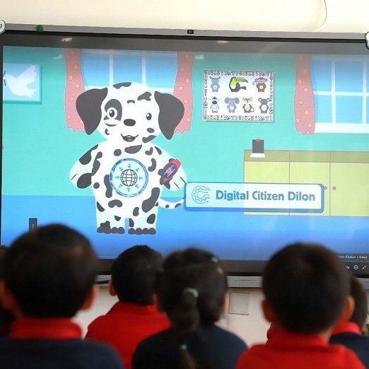 Children on the carpet watching Digital Citizen Dilon on the class screen